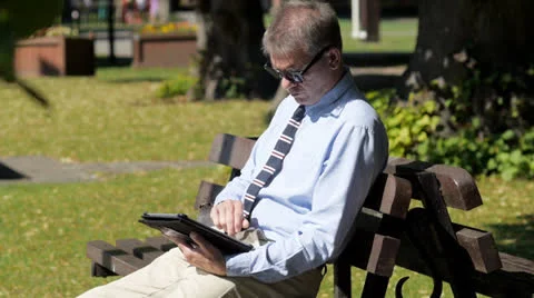 Man with tablet computer in park Stock Footage 26353511