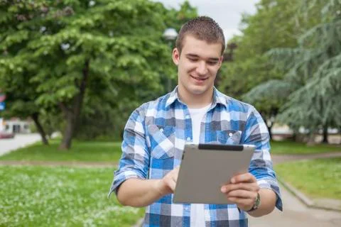 Man with tablet computer relax in park Stock Photos