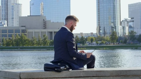 Man with tablet computer relaxing near river 스톡 동영상 120665955
