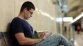 Man with tablet computer sits on the bench inside underground station HD Footage