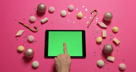 Man with tablet with green screen on pink background with festive winter decor Stock Footage 221489526