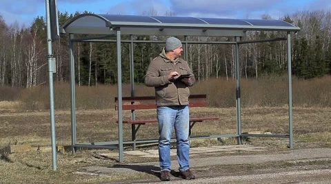 Man with tablet PC at the bus stop Stock Footage 49168586