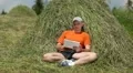 Man with tablet PC sits near haystack HD Footage