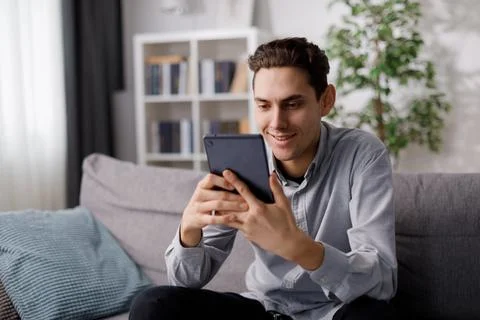 Man with tablet on sofa 스톡 사진