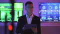 The man with a tablet standing on displays background 4k or 4k+ Resolution