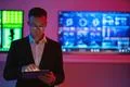 The man with a tablet standing on screens background Photo