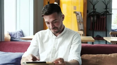 The man with the tablet is very much laughing in the cafe. Lifestyle. Stock Footage 77000821
