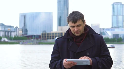 A man with a tablet on the waterfront. Video stock 91132652