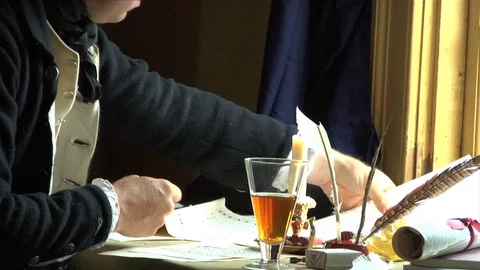 Man at tabletop, Quill writing by candle light &amp; by window, papers. Stock Footage 81237121