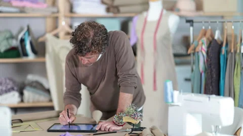 Man tailor makes pattern using tablet Stock Footage 317994459