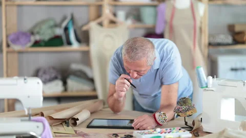 Man tailor makes pattern using tablet Stock Footage 320926647