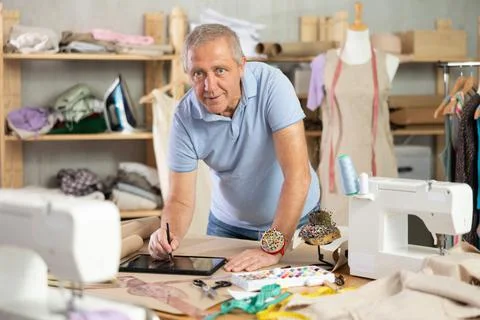 Man tailor makes pattern using tablet Stock Photos