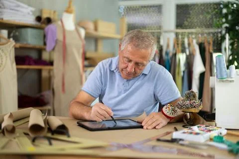 Man tailor makes pattern using tablet 库存照片