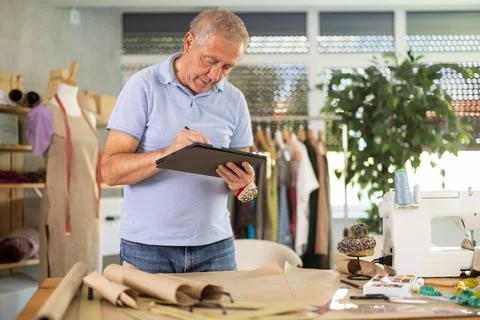 Man tailor makes pattern using tablet Stock Photos