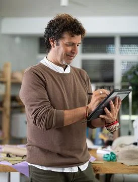 Man tailor makes pattern using tablet Stock Photos