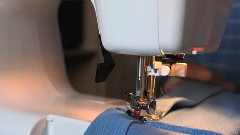 A man tailor in a sewing machine makes seams. Close-up of sewing Stock Footage 117034869