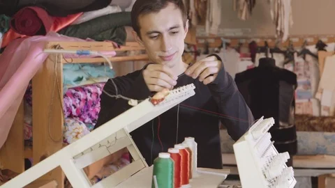 Man tailor worker is inserting thread in the embroidery machine Video stock 89332462