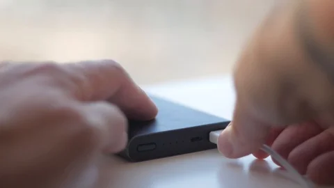 Man take the cable out of the portable charging Stock Footage 99569558