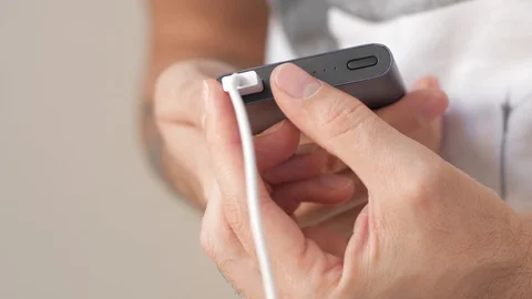 Man take the cable out of the portable charging Stock Footage 99569589