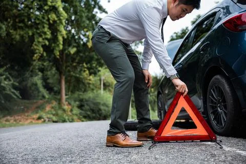 Man take down red warning triangle. Stock Photos