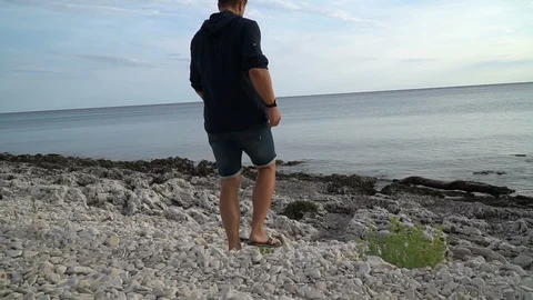 Man take a leak on a beach Stock Footage 94113088
