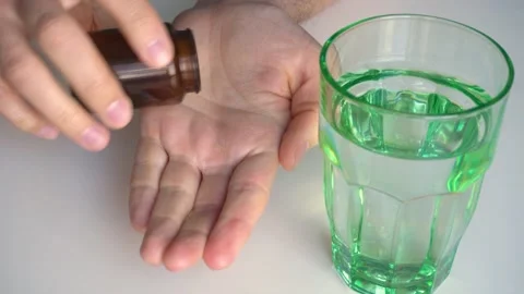 Man take open jar and take pills Stock Footage 195732980