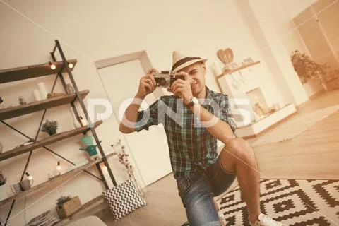 Man take a photo in loft interior with old soviet camera Stock Photos