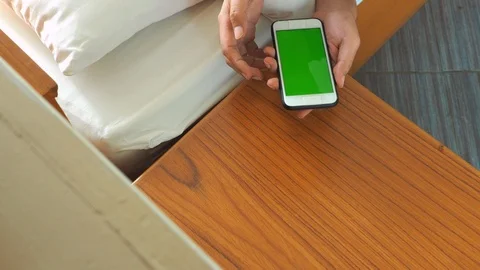 A man take a smartphone on the table near bed. Stock Footage 111056092