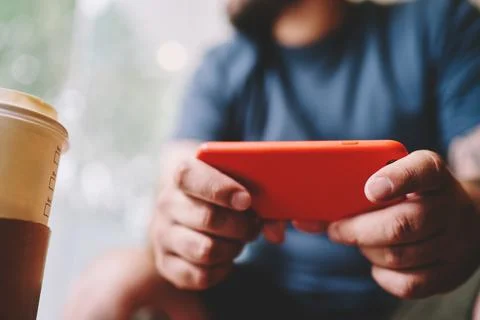 Man with takeaway coffee using smartphone Stock Photos
