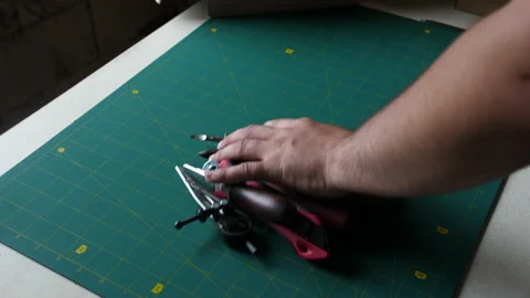 The man takes all the tools from the table with one hand. There is an empty Stock Footage 198496383