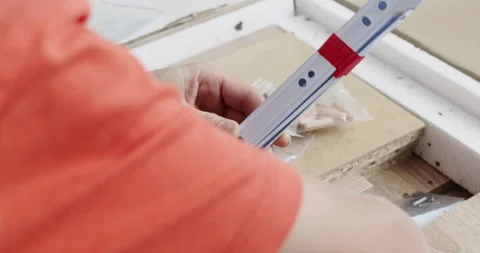 Man takes assembling parts out of box while boy takes hardware Stockbeeldmateriaal 286045832