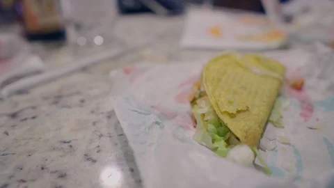 Man Takes a Bite of a Taco from a Fast Food Restaurant Video stock 129721933
