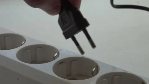 The man takes a black electric plug with a cord Stock Footage 148958108