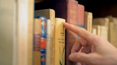 A man takes a book from a shelf Stock Footage 100639541