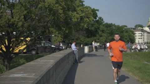 Man takes break and drinks water during the jogging. Vídeo Stock 52693143