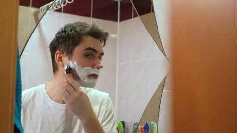 A man takes care of his beard, a guy applies shaving foam Stock Footage 264887855