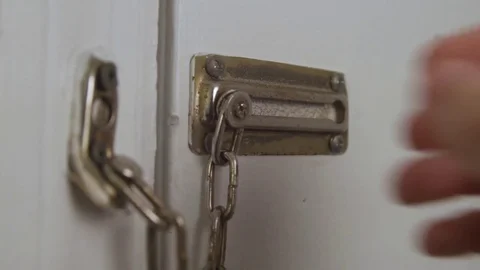 Man takes chain off door Stock Footage 76418623