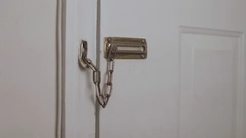 Man takes chain off door Stock Footage 76418644
