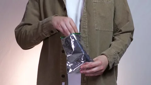 A man takes chips from a package and eats them. Junk food - chips. Stock Footage 311399558