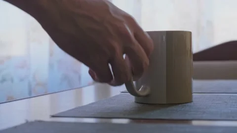 Man takes the cup from the table Stock Footage 163991840