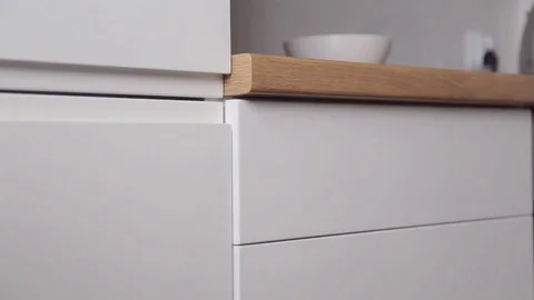 The man takes the cutlery from the pull-out kitchen box with the push system Stock Footage 81446382