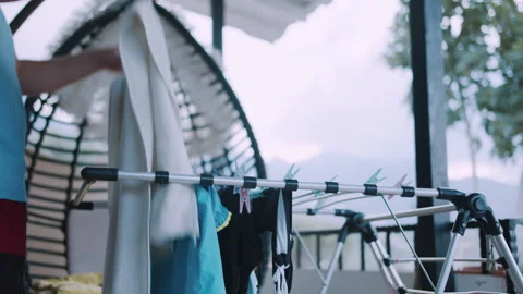 A man takes dry, washed laundry off the drying rack Stock Footage 316067229