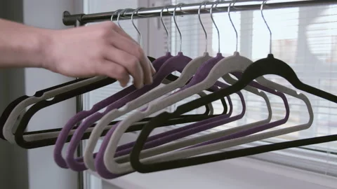 Man takes an empty clothes hanger from the rack while tracking the camera Stock Footage 153864326
