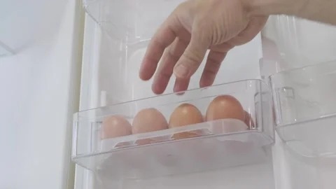 Man takes fresh raw egg out of refrigerator 動画素材 276208285