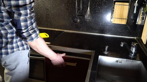 A man takes a frying pan in the kitchen and puts it on the stove Stock-Footage 86156262