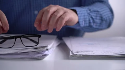 Man Takes Glasses from a Pile of Documents. Stock Footage 151463410