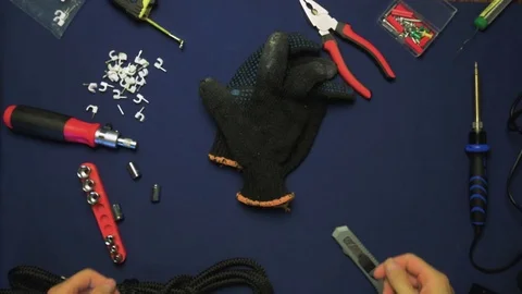 The man takes off his black working gloves, the tools are on the table Vídeo Stock 78996644