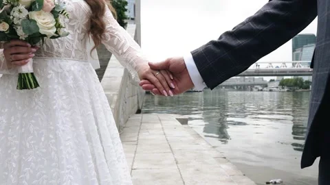A man takes his bride by the hand. Close-up shooting of lovers' hands Stock Footage 162381352