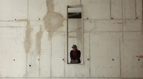 Man takes off his coat hat and red scarf in abandoned unfinished urban building Stock Footage 48025915