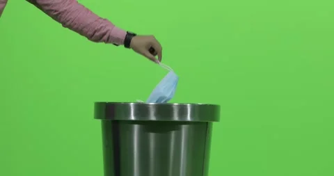 Man takes off his disposable face mask and throws into the trash can. Stock Footage 147121572